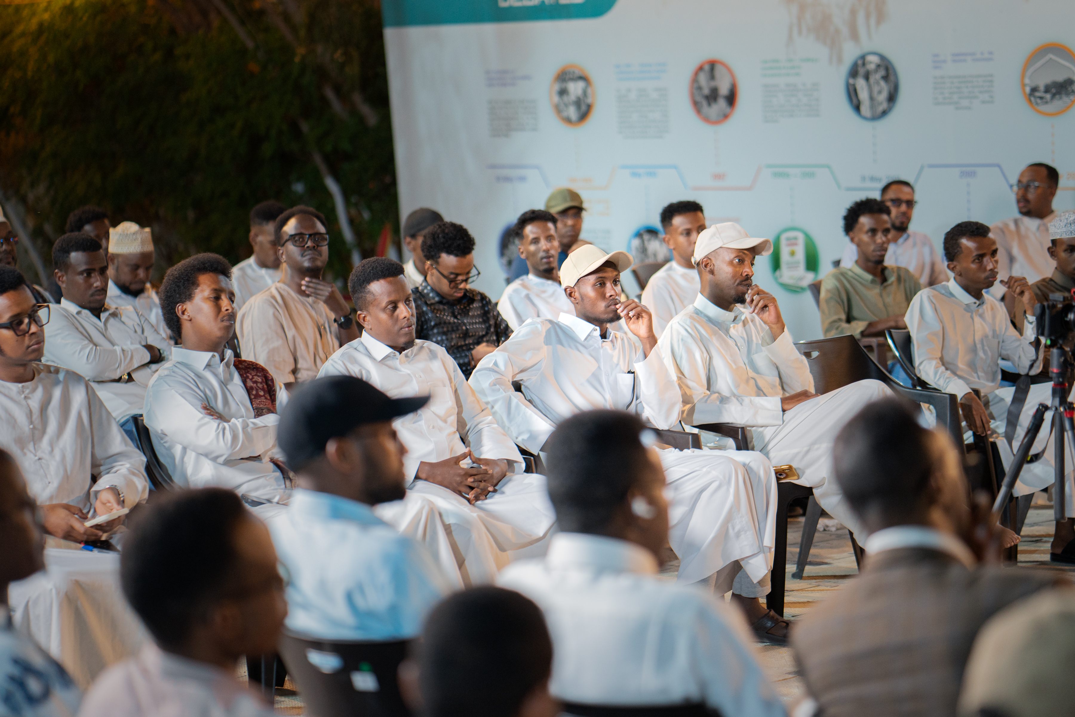 Young men listening attentively during a community debate