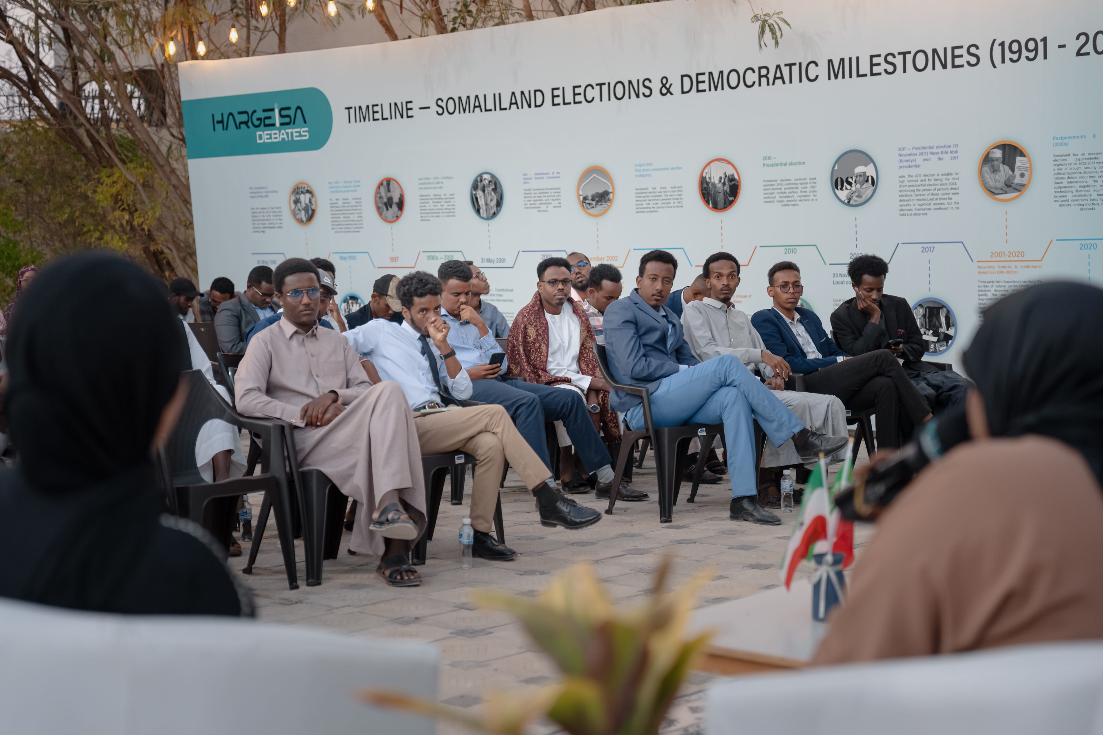 Young audience members listening during an outdoor forum